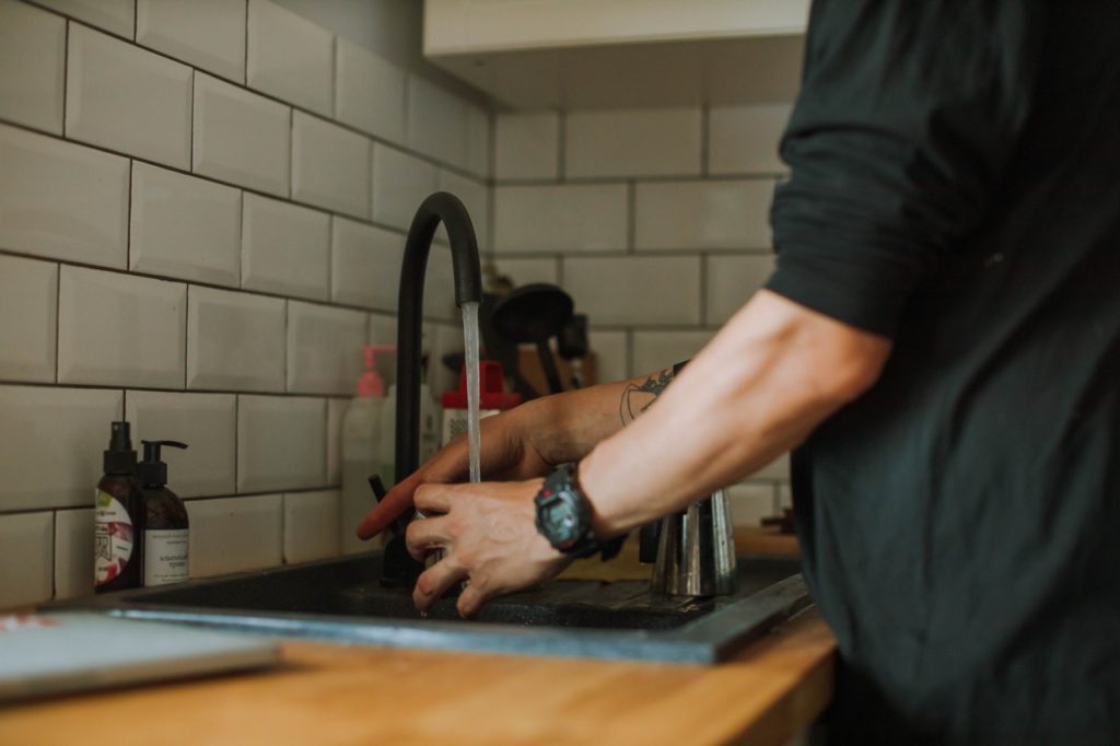 Man Using Kitchen Tap