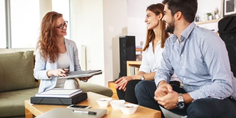 two women and a man sitting at the table and talking