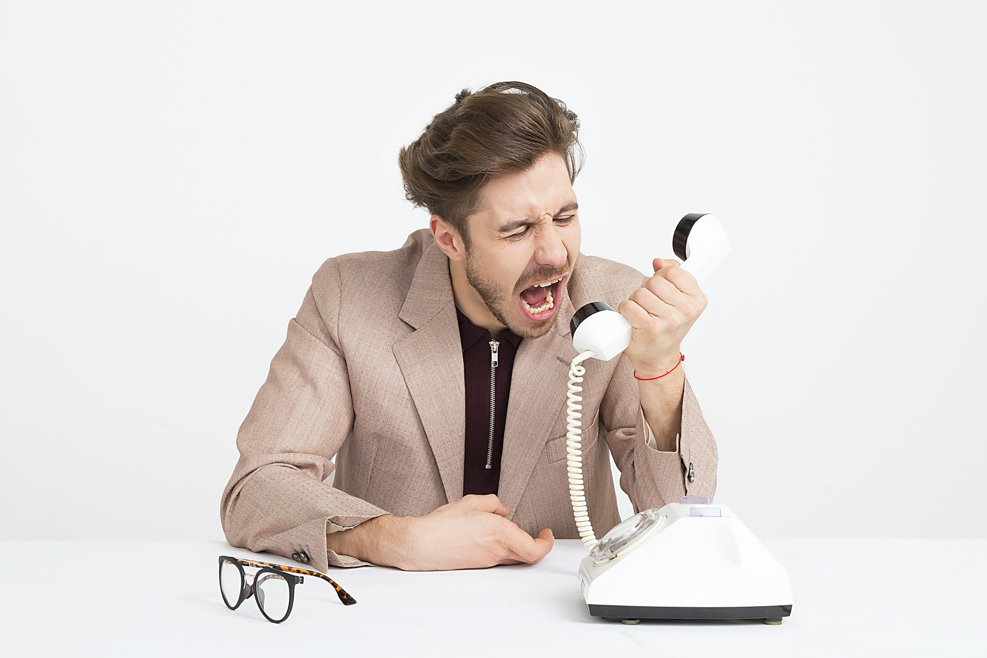 frustrated man yelling at a phone 